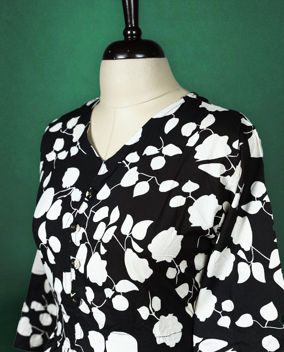 Black rayon kurti featuring bold white floral prints, designed with a V neckline, front button detailing, and a gathered waist, breezy and modern choice for casual wear.