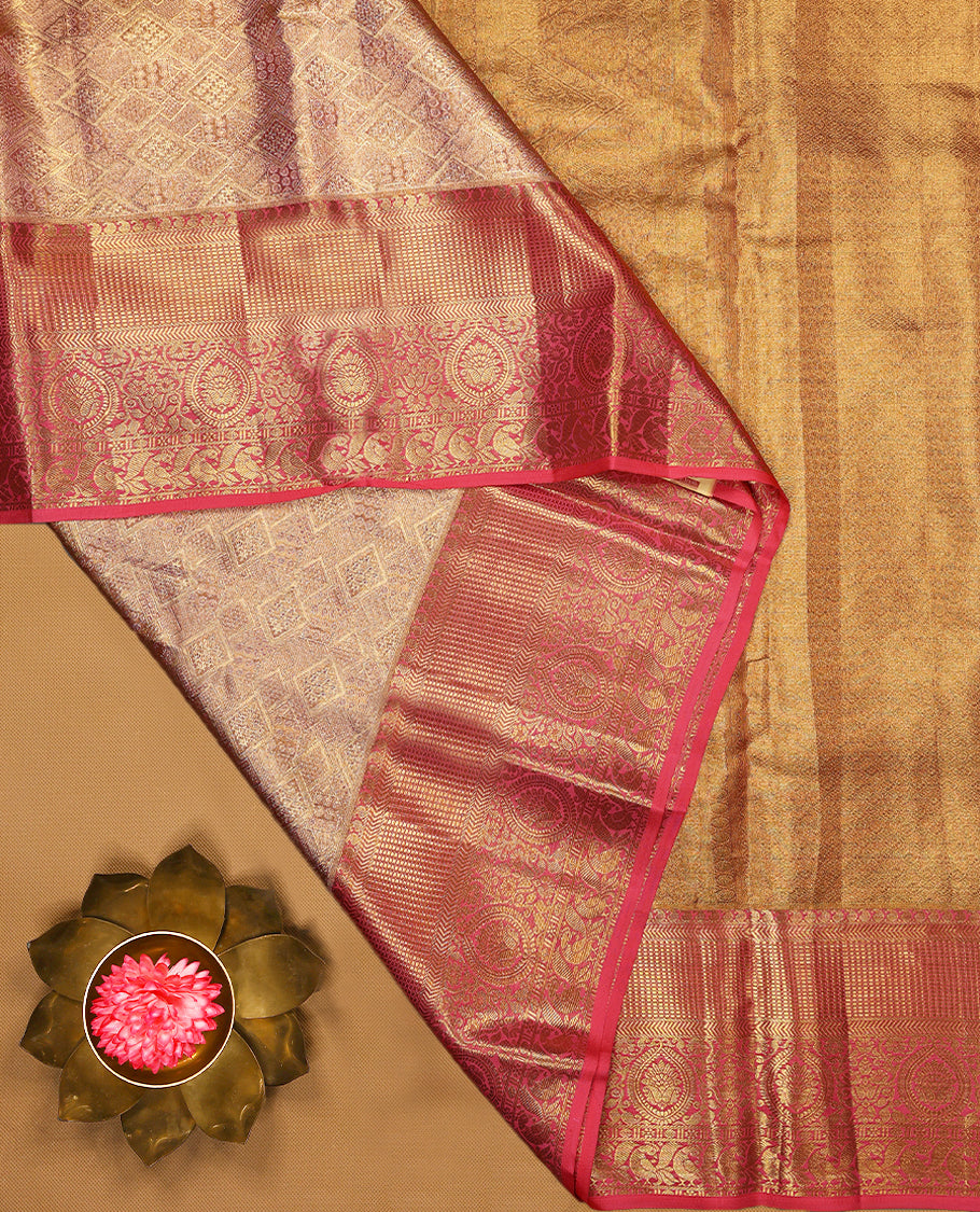 Golden Colour Kancheepuram tissue silk saree featuring intricate silver and pink Zari diamond motifs on the body, beautifully complemented by a contrasting traditional peacock and floral kodi design border, paired with a matching blouse.