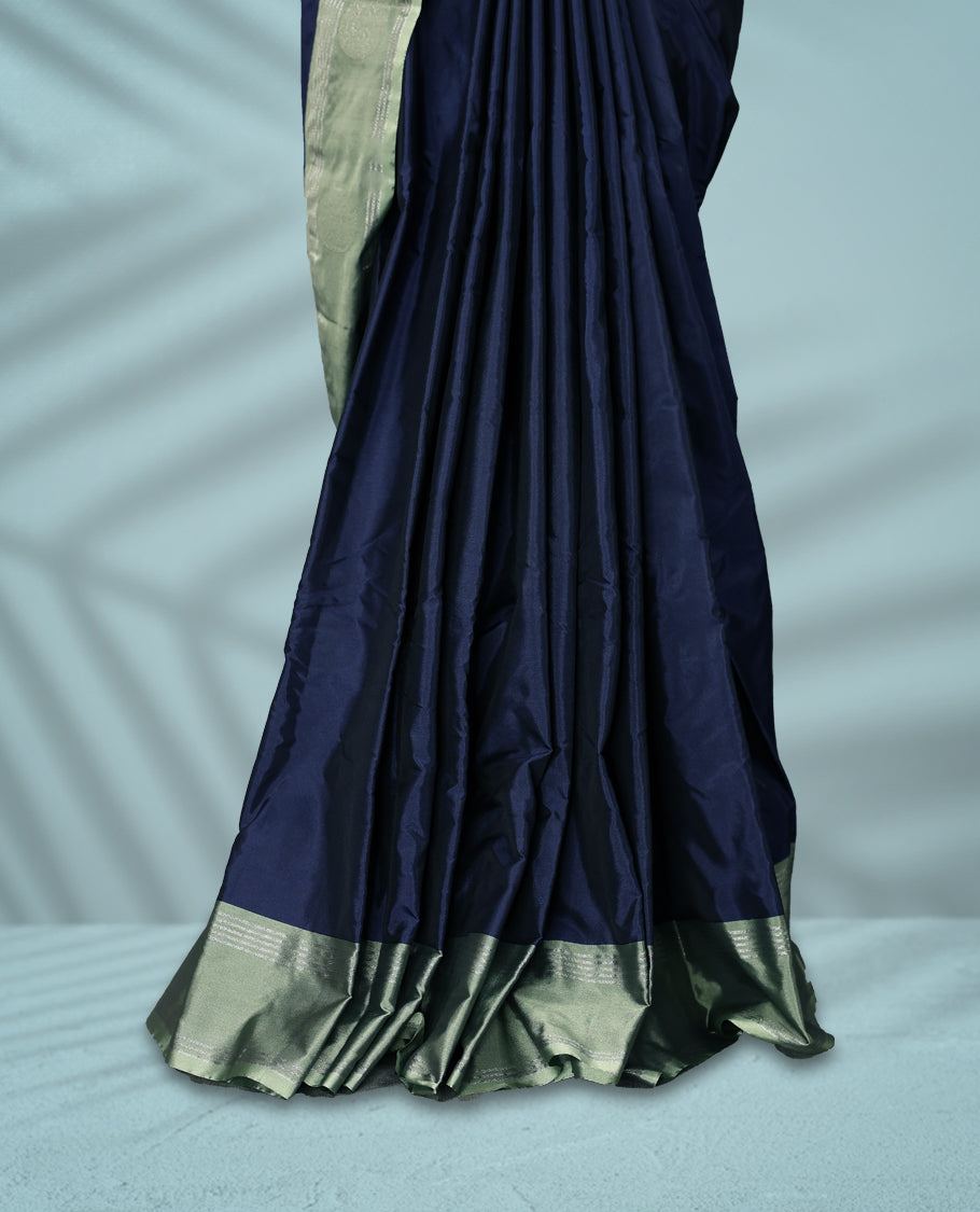 Navy blue Colour semi silk saree features Zari worked body enhanced by a pastel green zari border adorned with Silver circular motifs, and comes with a matching blouse.