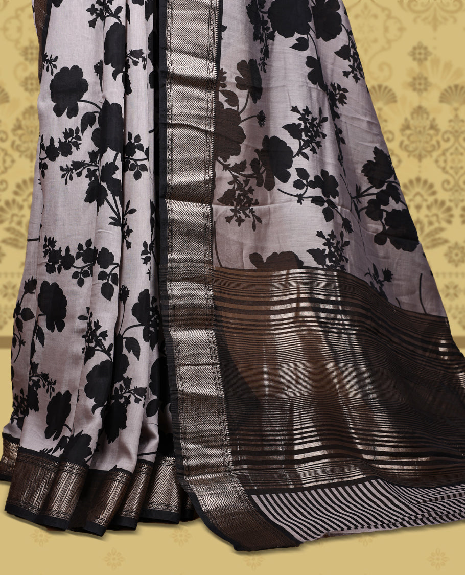 Grey colour saree adorned with bold black floral prints and a rich black zari border and stripped checkered pallu & Comes with a matching blouse piece.