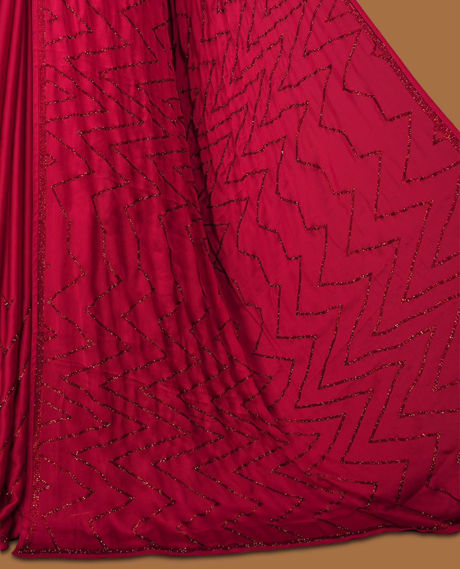 Dark Red Colour net shimmer fancy saree adorned with red stone buttas all over the body, paired with a delicate stone worked border and matching blouse featuring floral vine stone embroidery.