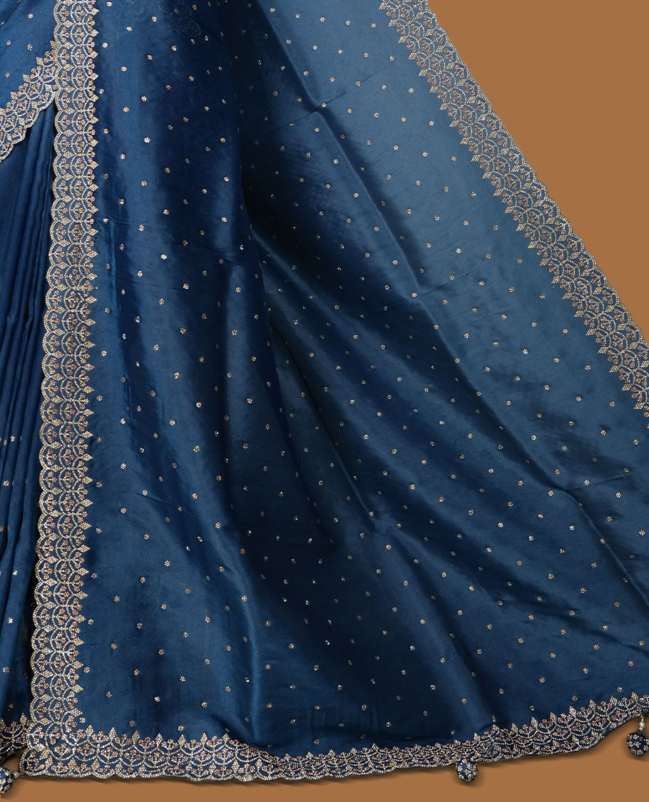 Blue colour net shimmer fancy saree adorned with white stone buttas all over the body, paired with a delicate stone worked border, with matching blouse