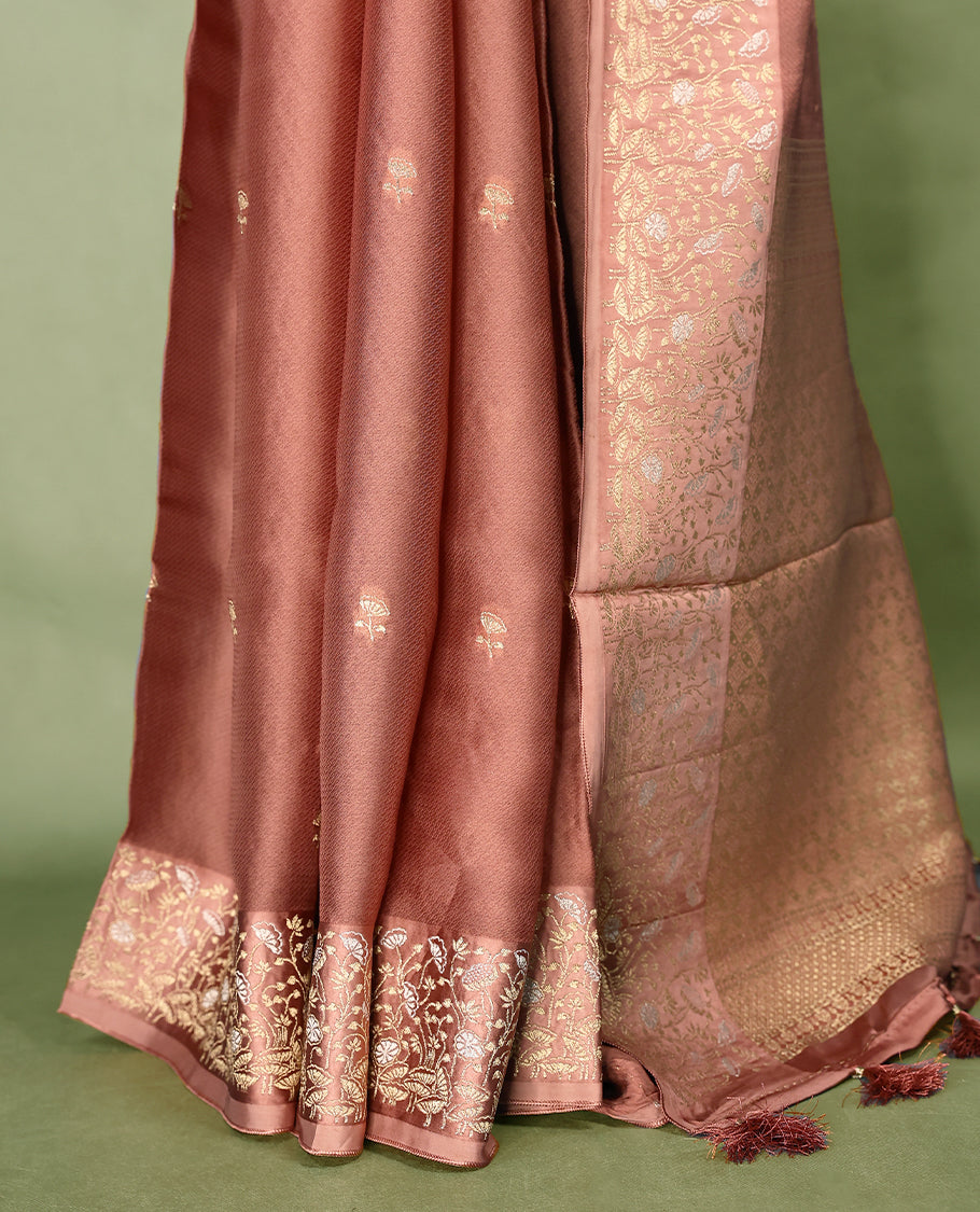Pastel brown colour pure Banaras crepe saree showcases elegant Gold zari Flower Motifs all over the body, a traditional gold & Silver zari border, a rich intricately woven pallu, and comes with a matching blouse.