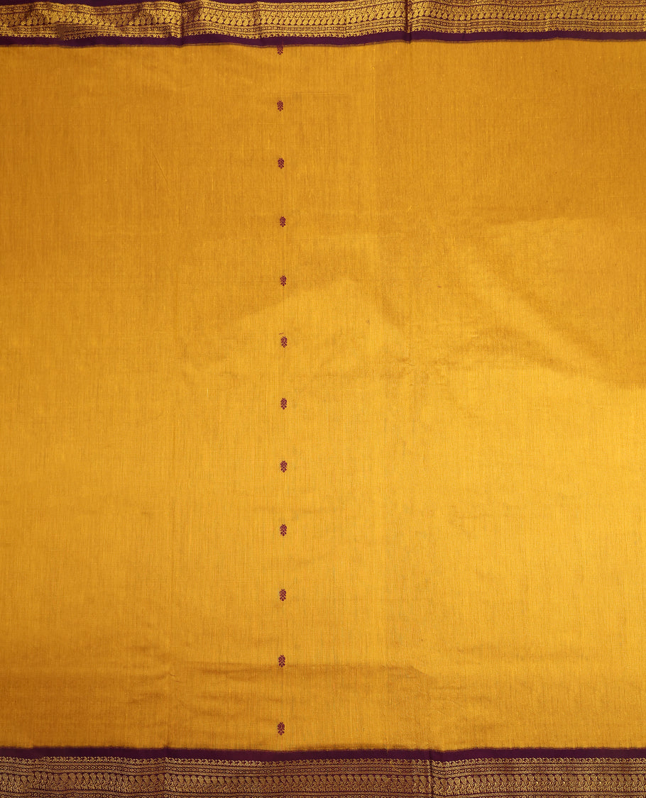 Mustard Yellow colour Kalyani cotton saree featuring woven maroon butta motifs throughout the body, paired with a rich Purple colour traditional zari woven border and pallu, with matching blouse.