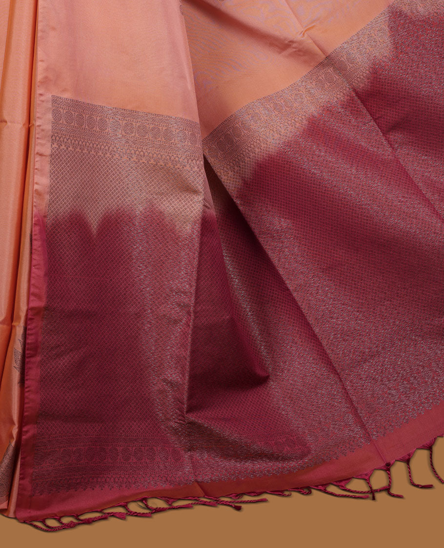Dark peach colour semi soft silk saree adorned with delicate woven floral motifs on the body, complemented by a contrast red colour woven pallu with intricate detailing and tassel accents without border & Comes with a matching blouse piece.