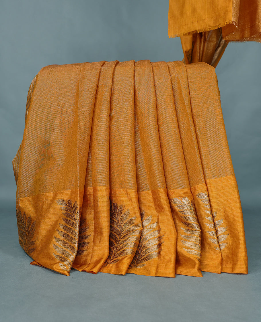 Mustard Colour Semi Tussar Silk saree featuring golden zari horizontal lines across the body, adorned with bold Leaf motifs on the border, paired with a matching blouse.
