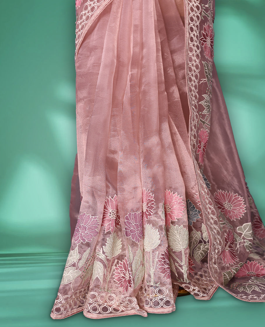 Lignt Pink colour organza designer saree featuring delicate pastel floral embroidery in pink, mint green, and white across the body, with a scalloped border accentuated by floral threadwork, and a gracefully embroidered pallu paired with matching blouse.