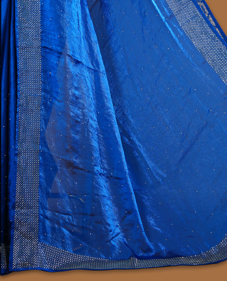 Royal Blue colour chiffon designer saree, featuring dainty scattered stones on the body, enriched with dense stone work and a heavy metallic stone border and pallu, paired with a matching blouse.