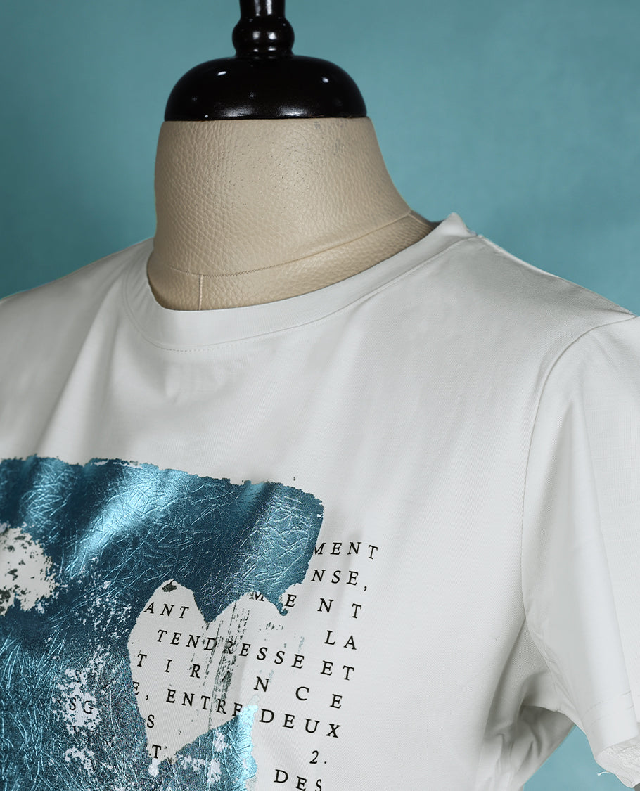 White graphic T shirt featuring a round neck and short sleeves, designed with a blue abstract print and text details for a contemporary, artistic vibe.