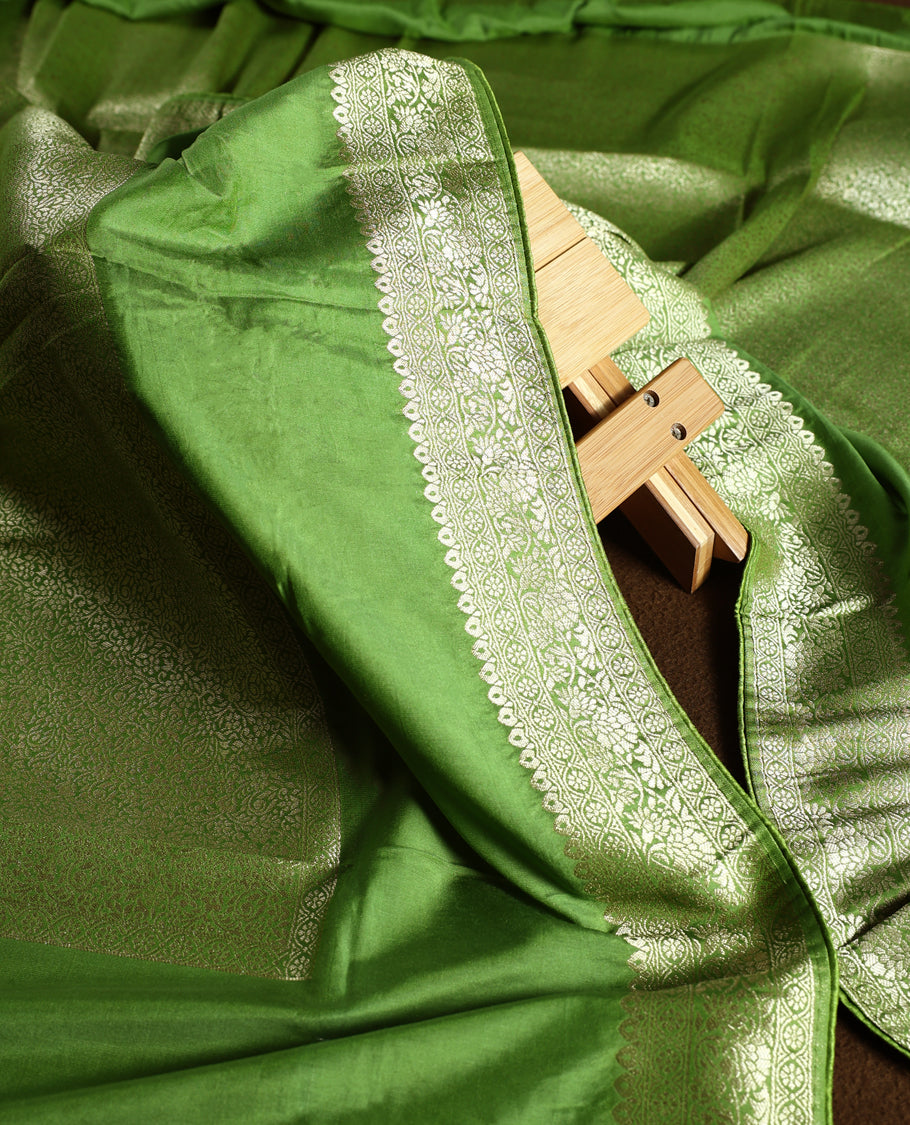Light green colour churidhar material with elegant golden zari floral weaves and stone embellishments, paired with a plain matching bottom and dupatta.