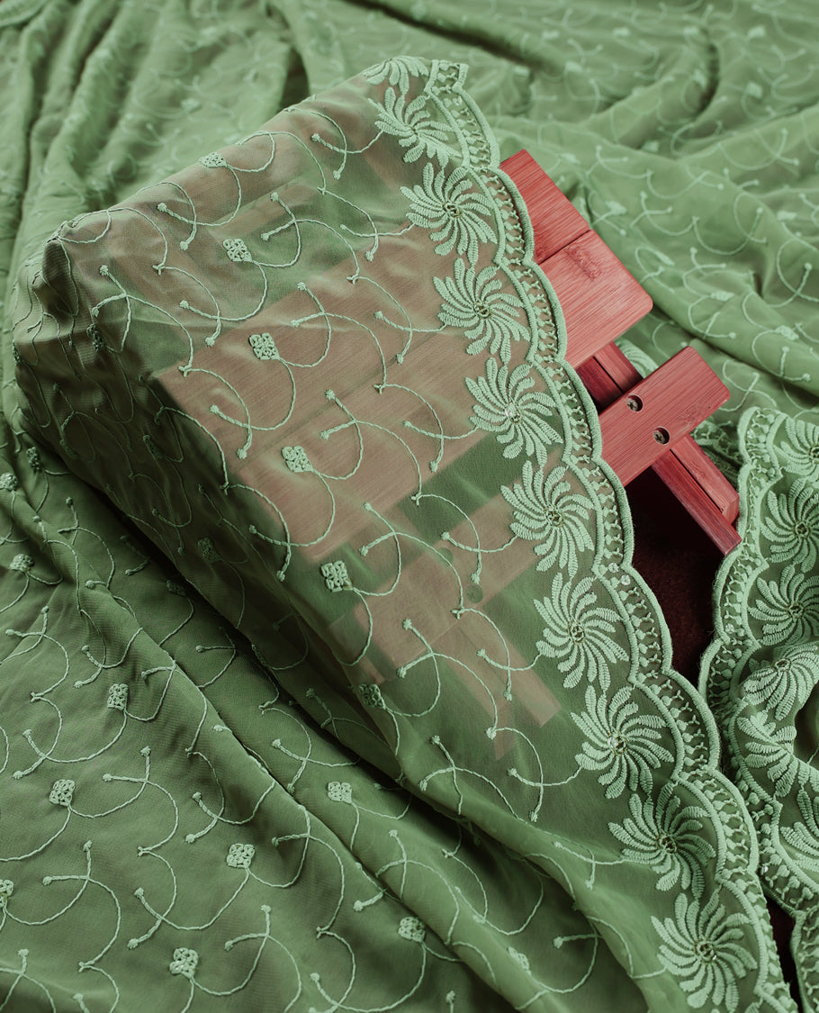 Elegant pastel green churidhar material adorned with intricate floral embroidery and delicate sequin highlights, paired with a plain matching bottom and embroidered dupatta, perfect for festive celebrations and graceful occasions.