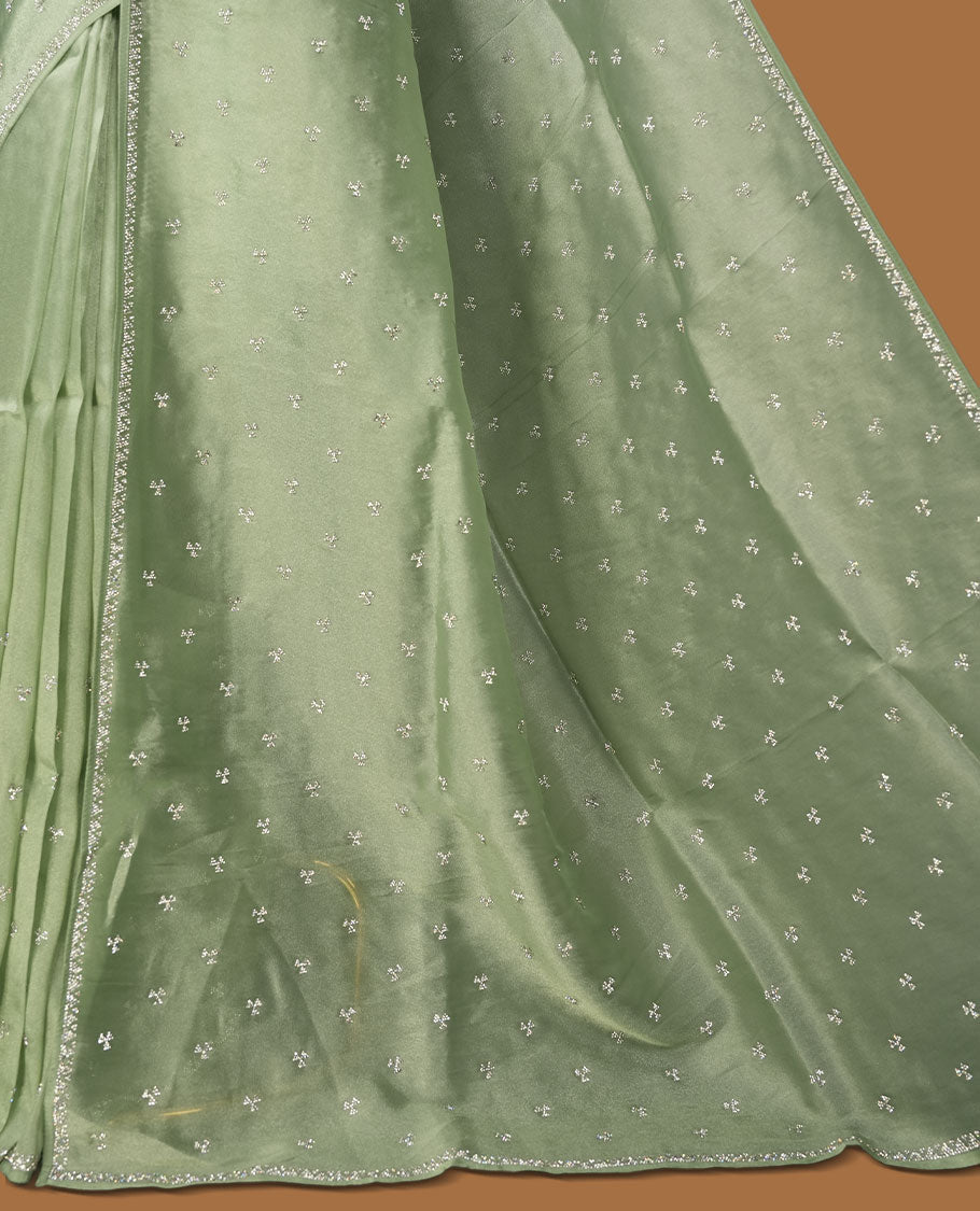 Pastel Mint colour net shimmer fancy saree adorned with white stone buttas all over the body, paired with a delicate stone worked border, with matching blouse