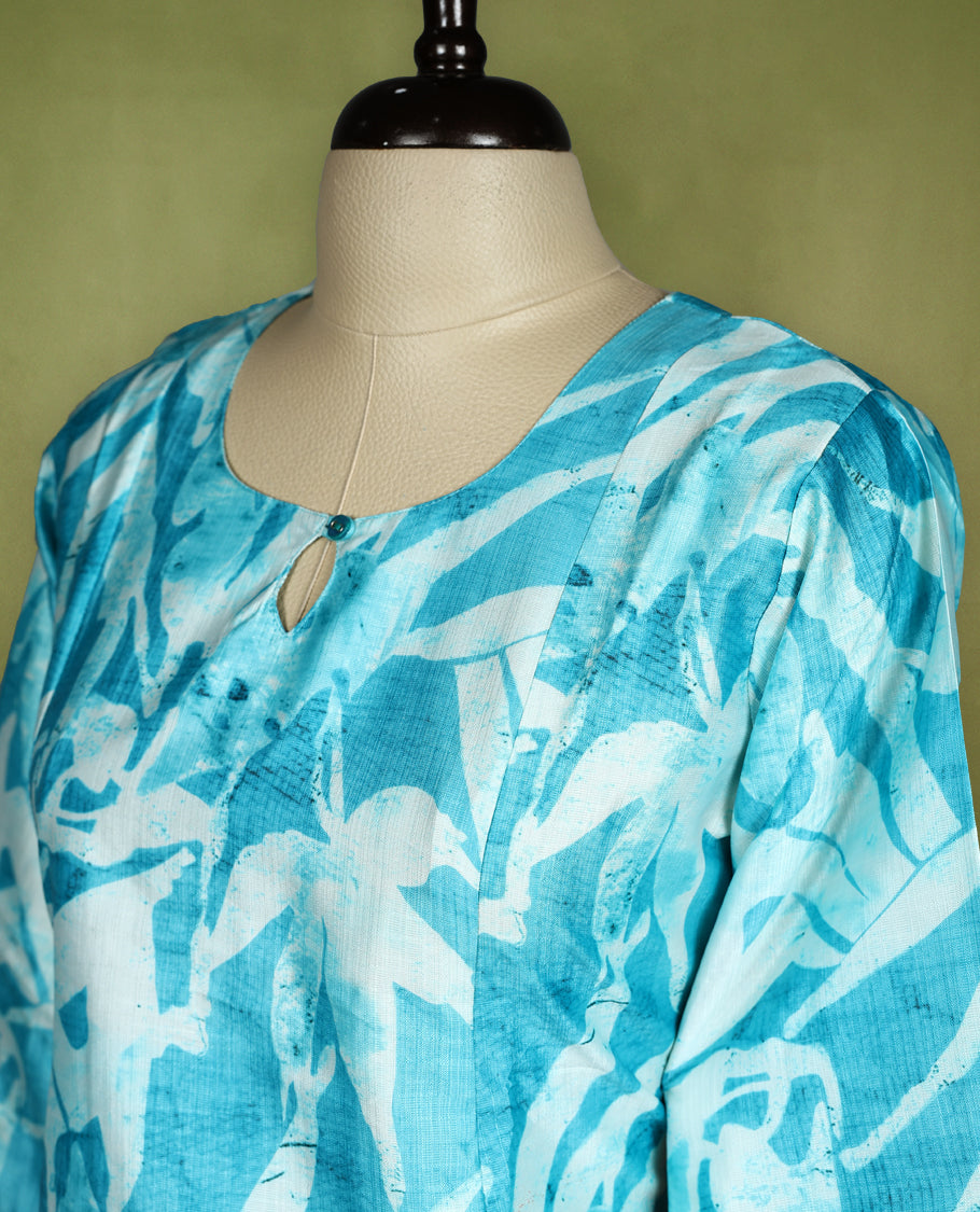Bright turquoise blue straight cut kurti featuring bold Off white abstract prints, styled with a round neckline and keyhole detail, 3/4th sleeves and side slits, ideal for everyday summer wear.