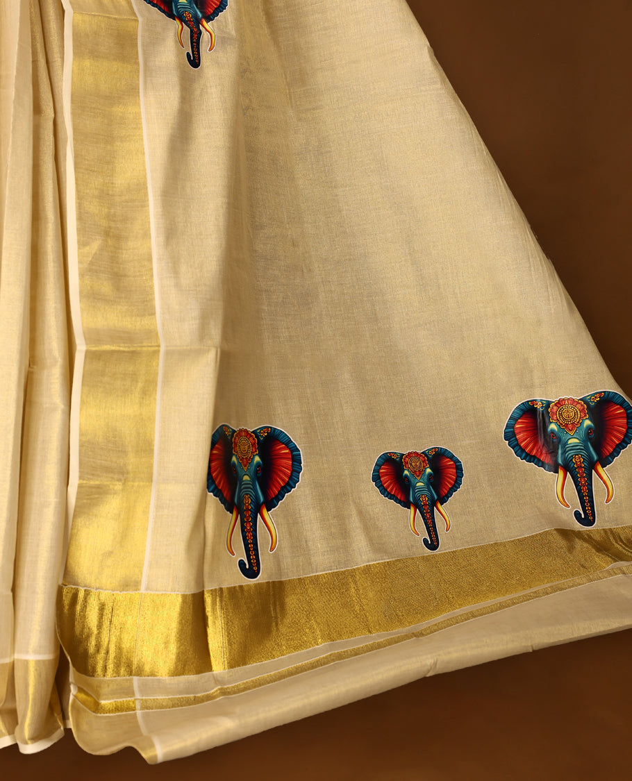 Light Gold colour Tissue Kerala saree featuring Elephant prints on body and a beautifully woven Gold Kasavu border, paired with a matching blouse perfect for festive occasions.