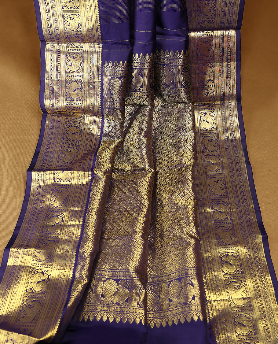 Navy blue Colour pure traditional Kancheepuram silk saree featuring antique zari line patterns on the body, complemented by a traditional border adorned with peacock and elephant motifs, and paired with a matching blouse.