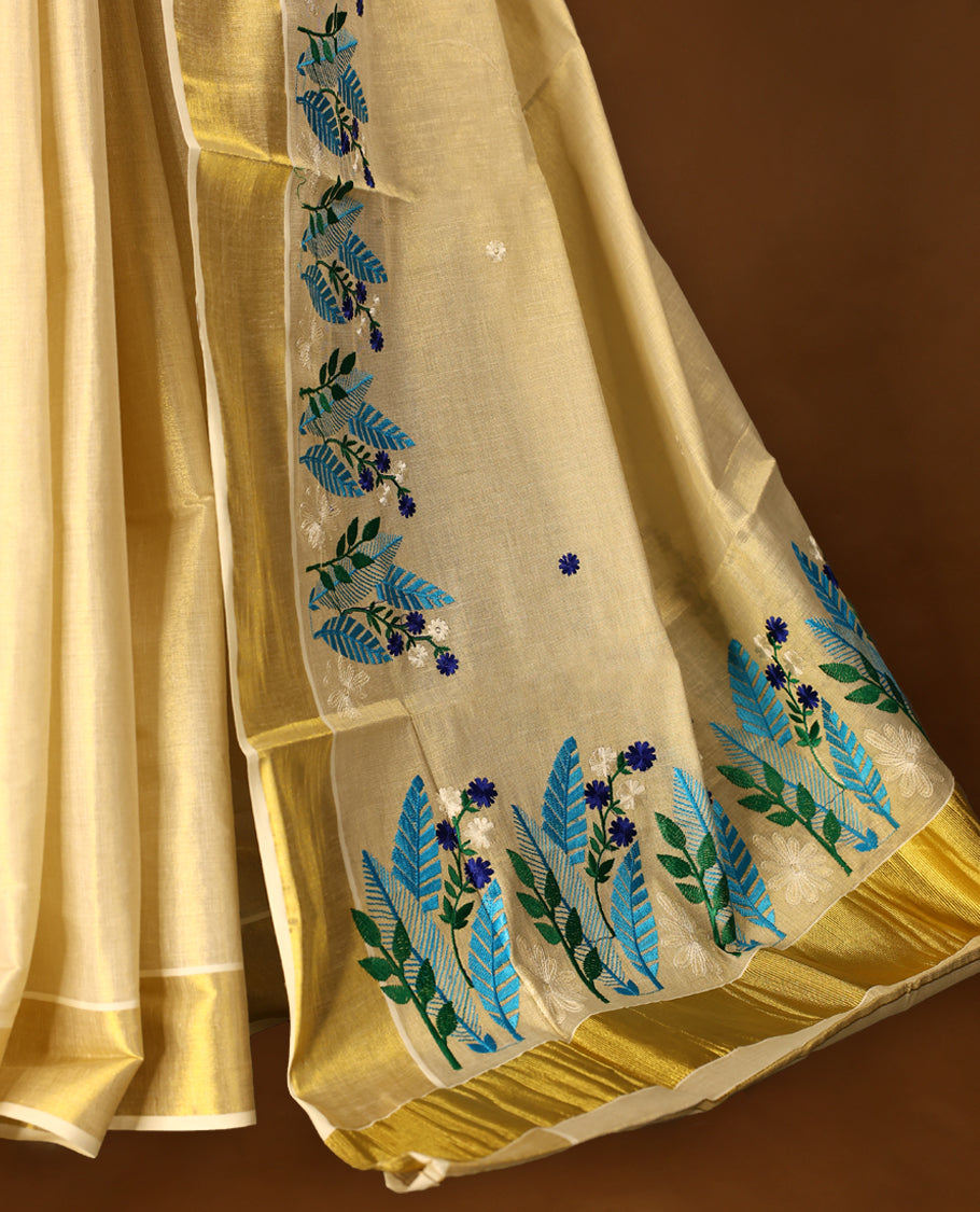 Light Gold colour Tissue Kerala saree featuring Plain body and a beautifully woven Gold Kasavu border with multi  colour Heavy Floral embroidery work, paired with a matching blouse perfect for festive occasions.