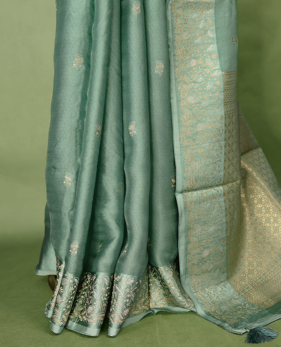 Pastel Green colour pure Banaras crepe saree showcases elegant Gold zari Flower Motifs all over the body, a traditional gold & Silver zari border, a rich intricately woven pallu, and comes with a matching blouse.