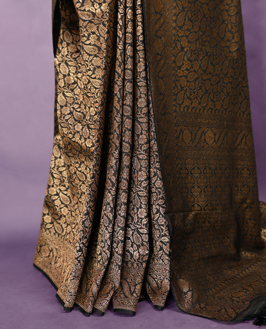 Black colour semi Banaras Katan silk saree featuring intricate Antique Bronze zari floral and vine patterns woven throughout the body, enhanced with a rich traditional border and detailed pallu, paired with a matching blouse piece.