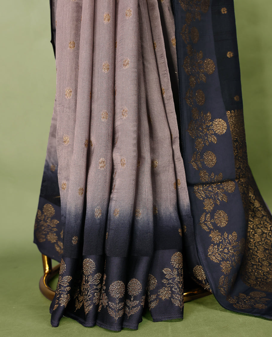 Grey and dark blue double shade semi Banaras Tussar Georgette saree adorned with elegant antique gold zari floral motifs across the body, featuring a detailed woven border and grand pallu, paired with a matching blouse piece.