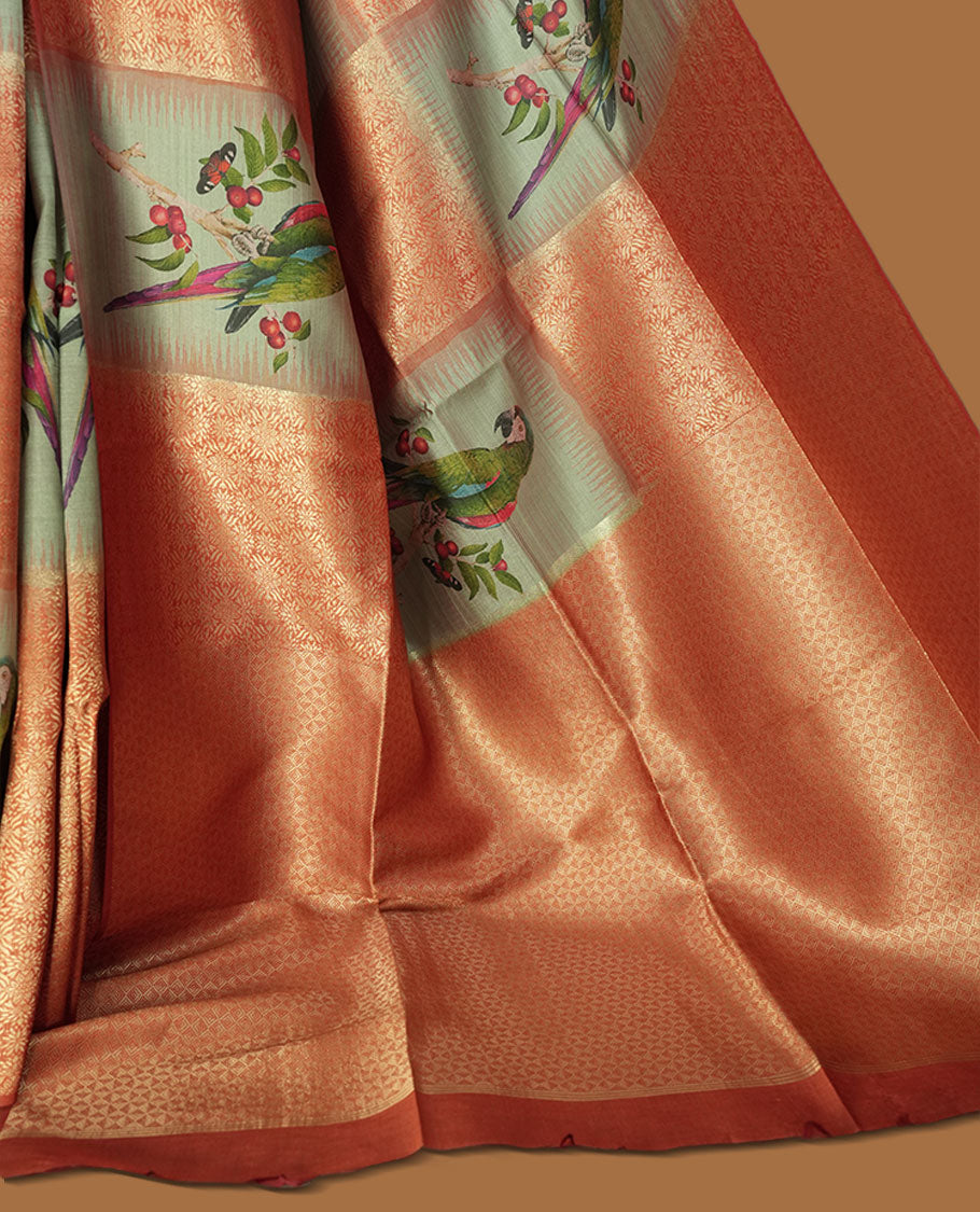 Peach and pastel green semi tussar Banarasi saree featuring artistic parrot prints perched on berry-laden branches across the body, with gold geometric woven patterns, an elegant peach zari border, and a matching blouse.