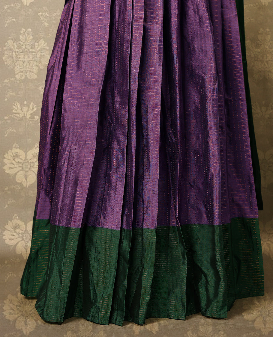 Lavender colour semi-stitched traditional half saree in semi Banarasi silk, featuring a checked design with a Bottle Green bordered skirt. It is paired with a Rangoli georgette drape and comes with a blouse that matches the skirt’s border.