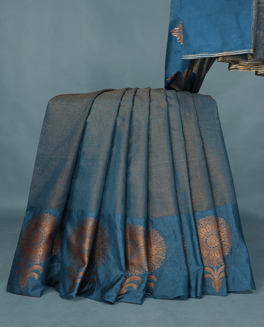 Blue Colour Semi Tussar Silk saree featuring golden zari horizontal lines across the body, adorned with bold floral motifs on the border, paired with a matching blouse.
