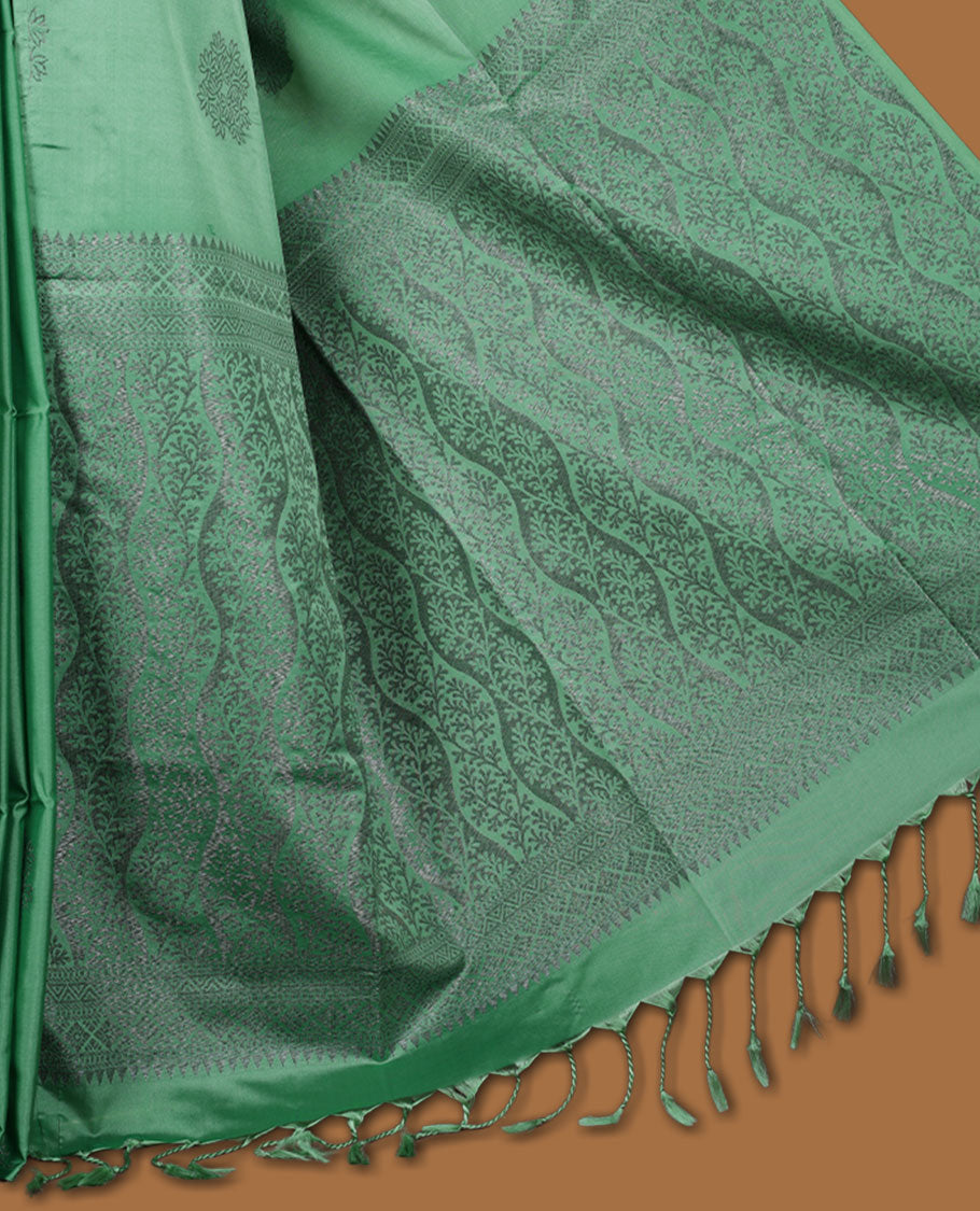 Jungle green colour semi soft silk saree adorned with delicate woven floral motifs on the body, complemented by a Self colour woven pallu with intricate detailing and tassel accents without border & Comes with a matching blouse piece.
