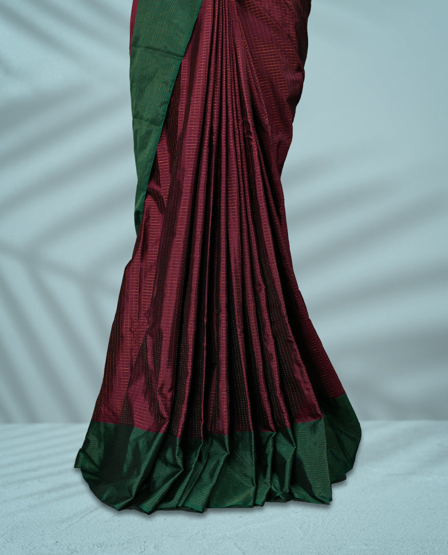 Deep Grape Colour semi silk saree features an elegant copper zari check pattern, complemented by a forest green border and a matching blouse