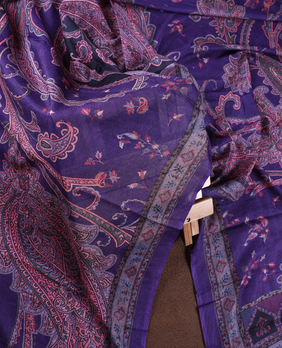Dark lavender colour churidhar material featuring intricate paisley prints and delicate embroidery, paired with a plain matching bottom and a printed dupatta.