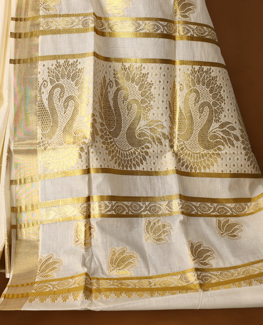Elegant Off-white colour cotton Kerala saree with golden Peacock motifs on body, Gold zari kazavu border, Rich Pallu paired with matching blouse.
