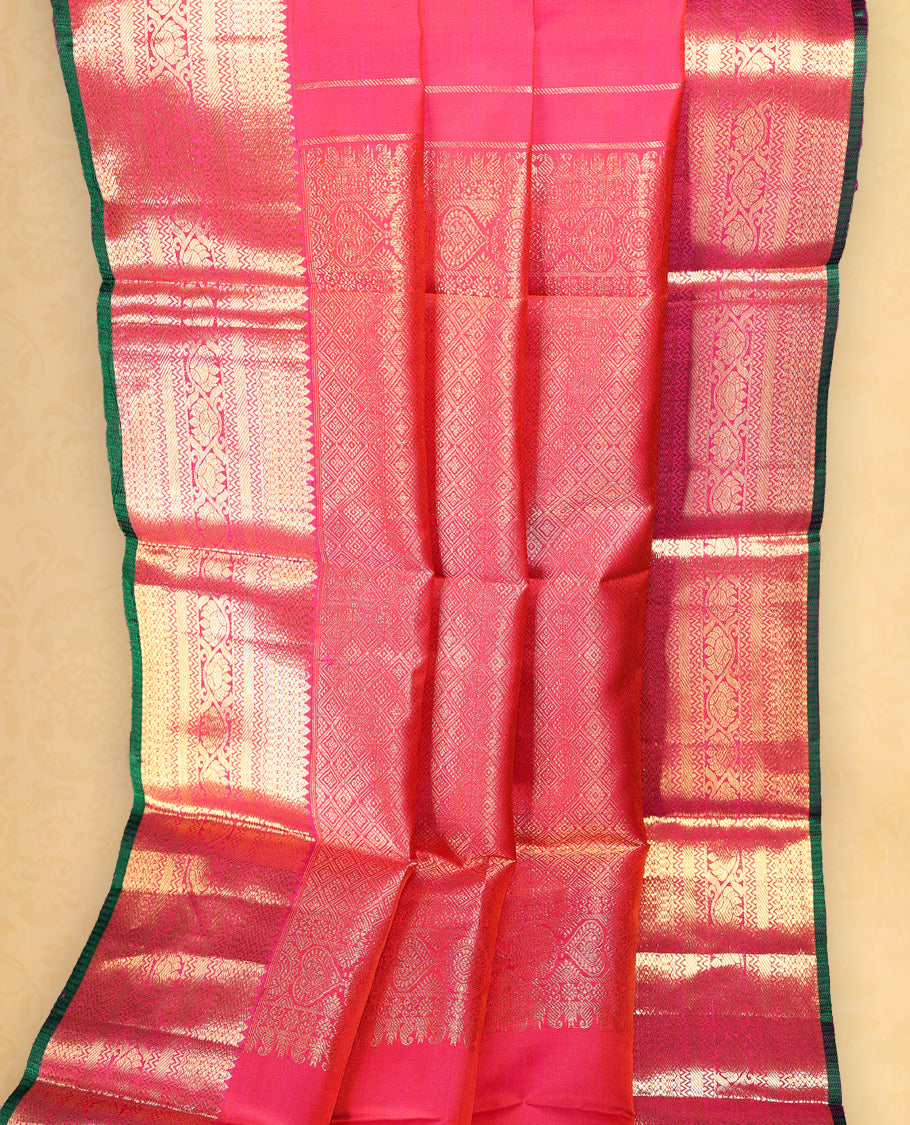 Rani pink pure Kancheepuram saree with gold zari paisley motifs on the body traditional border with floral kodi pattern and green piping, grand pallu with diamond motifs paired with matching blouse