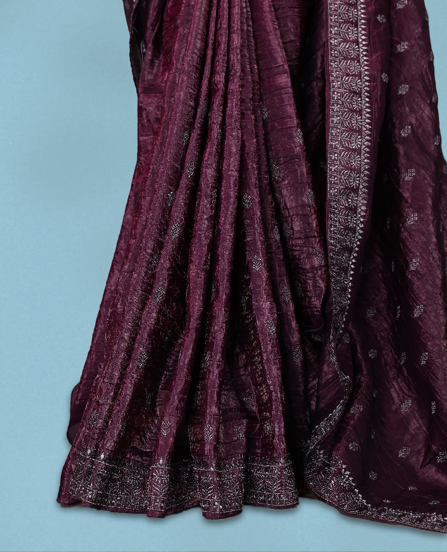 Deep Grape Colour crush soft silk saree, textured body with a natural crinkled finish, adorned with intricate Silver colored floral Motifs and complemented by a delicate Silver Zari embroidery border, paired with a matching blouse