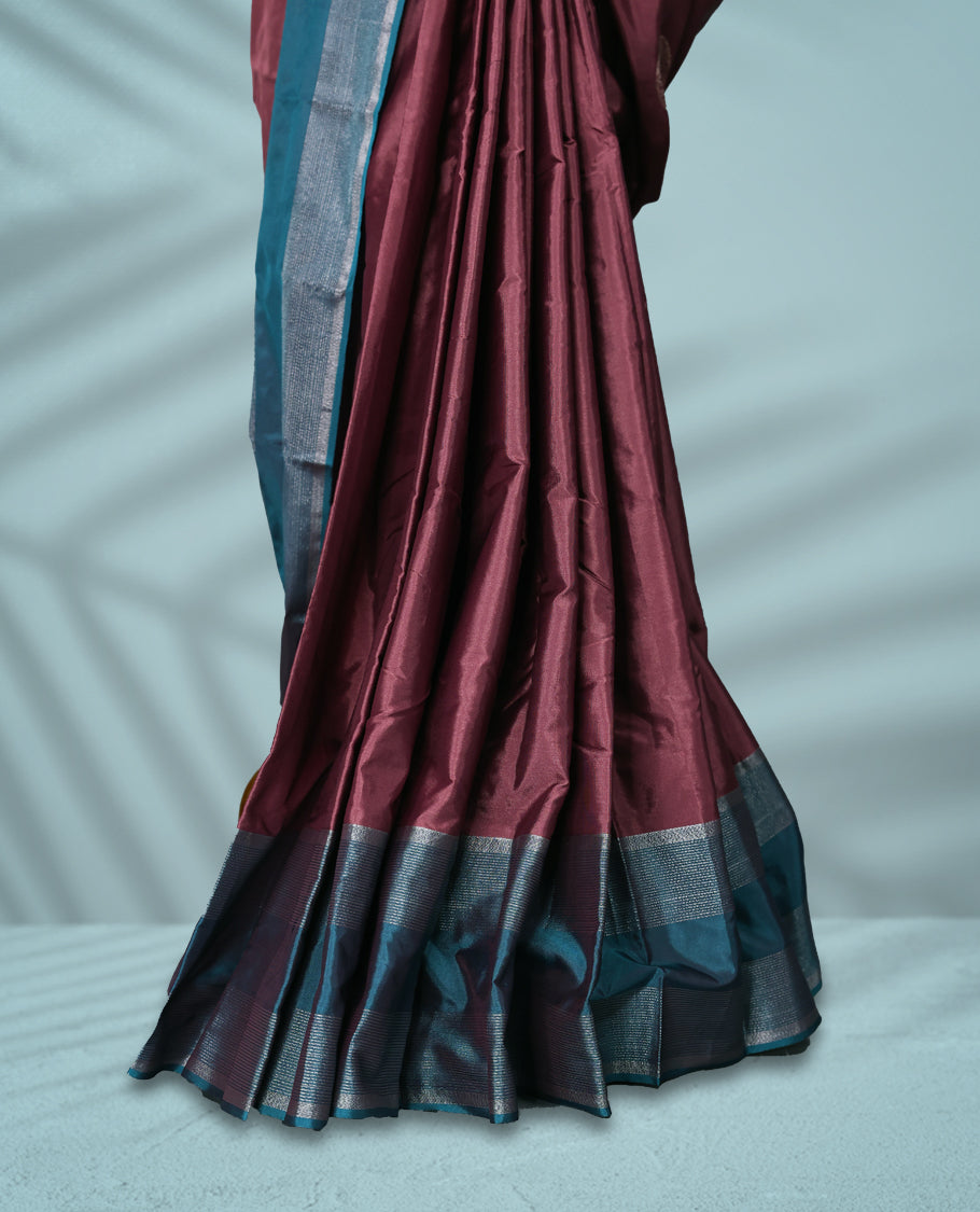 Onion coloured semi silk saree features silver zari motifs and is paired with a contrasting teal blue and silver zari border, with a matching blouse.