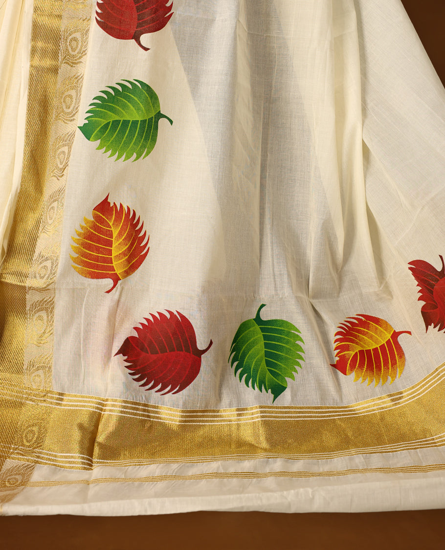 Elegant off white cotton Kerala saree adorned with vibrant multicolor leaf motifs, highlighted by a rich golden zari border and pallu paired with matching blouse.