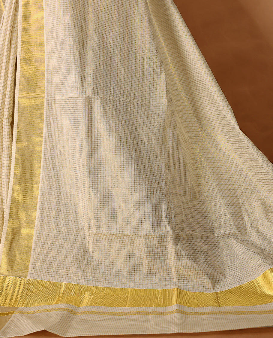 Elegant off white colour cotton Kerala saree featuring Tiny Checked body, gold zari traditional kasavu border offering a classic and graceful look, paired with a matching blouse.