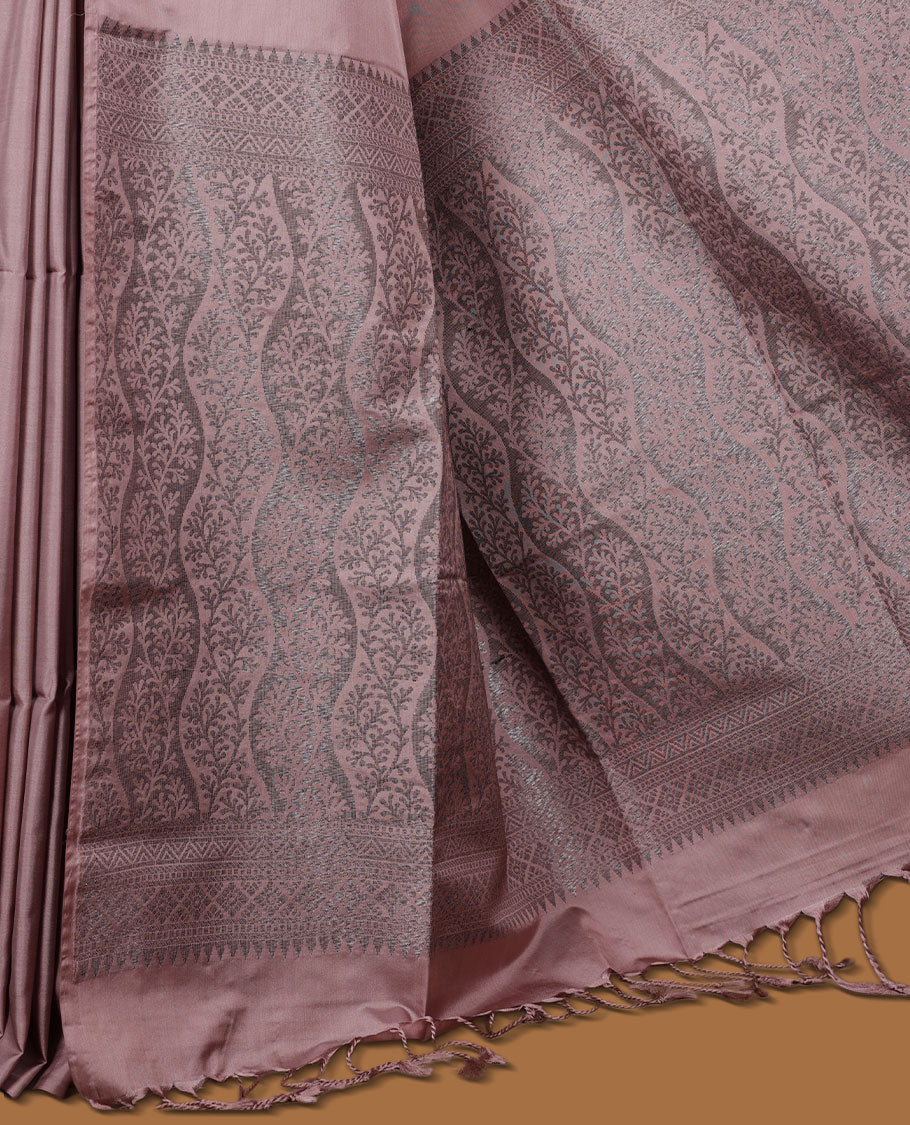 Pinkish beige colour semi soft silk saree adorned with delicate woven floral motifs on the body, complemented by a Self colour woven pallu with intricate detailing and tassel accents without border & Comes with a matching blouse piece.