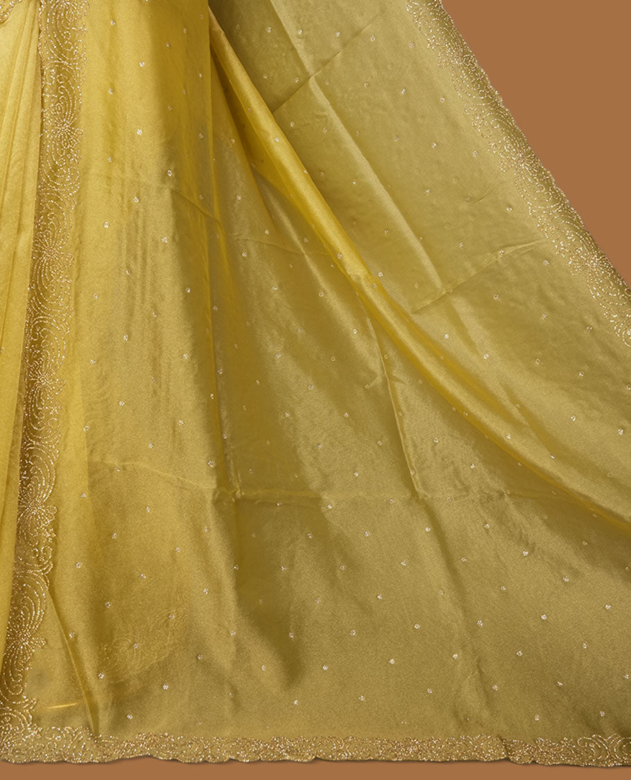 Golden olive colour net shimmer fancy saree adorned with white stone buttas, paired with a delicate stone worked border and matching blouse.