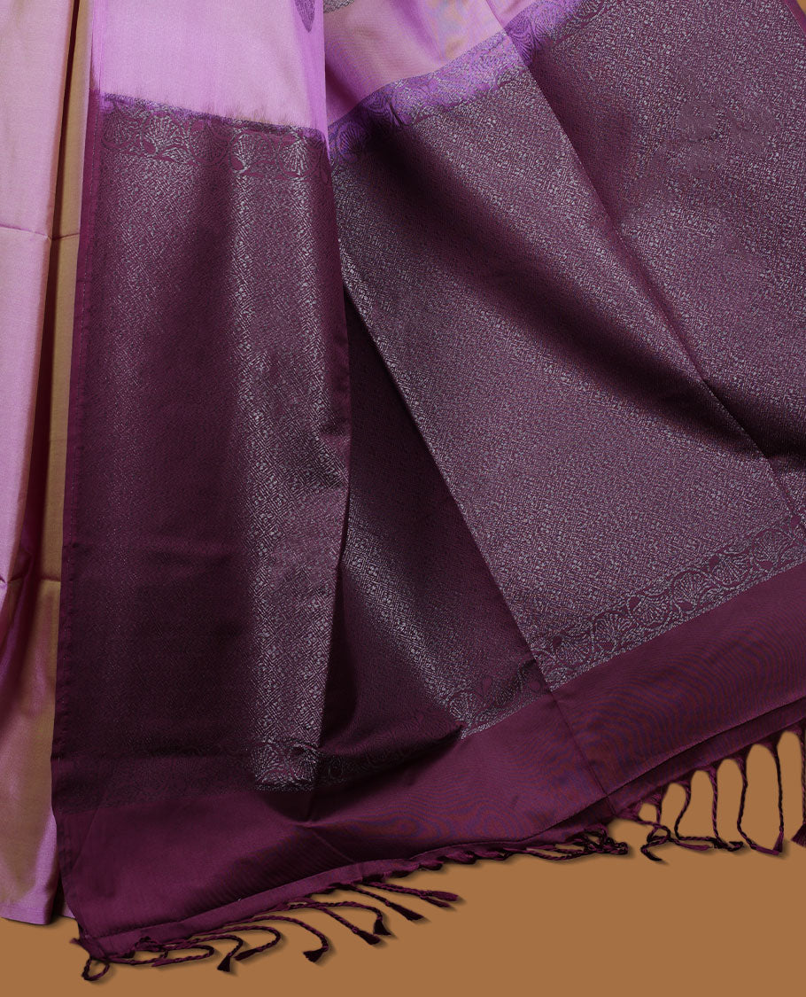 Lavender colour semi soft silk saree adorned with delicate woven floral chakkram motifs on the body, complemented by a contrast purple colour woven pallu with intricate detailing and tassel accents without border & Comes with a matching blouse piece.