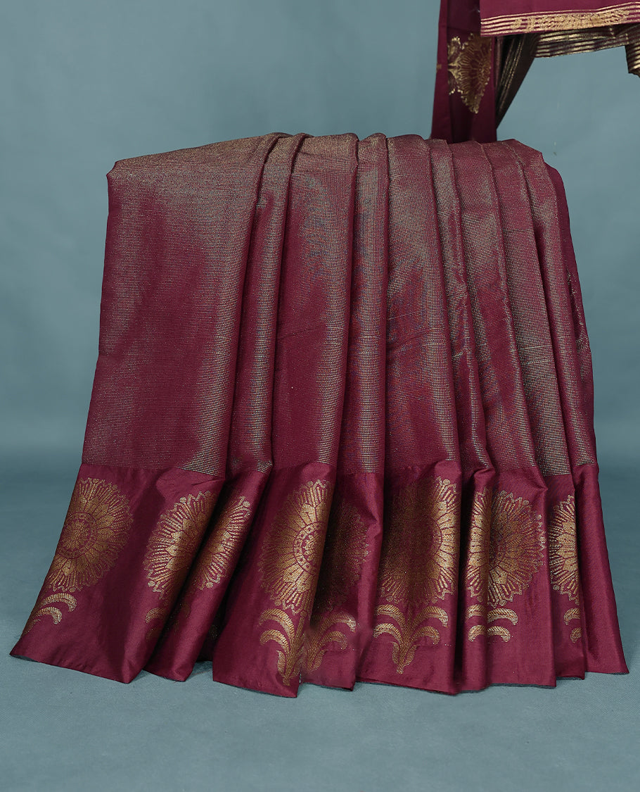 Dark Maroon Colour Semi Tussar Silk saree featuring golden zari horizontal lines across the body, adorned with bold floral motifs on the border, paired with a matching blouse.