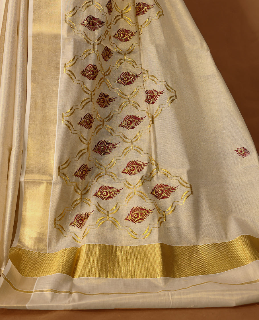 Elegant Light Gold colour Tissue Kerala saree featuring peacock feather embroidery worked body and traditional golden zari kasavu border offering a classic and graceful look, paired with a matching blouse.