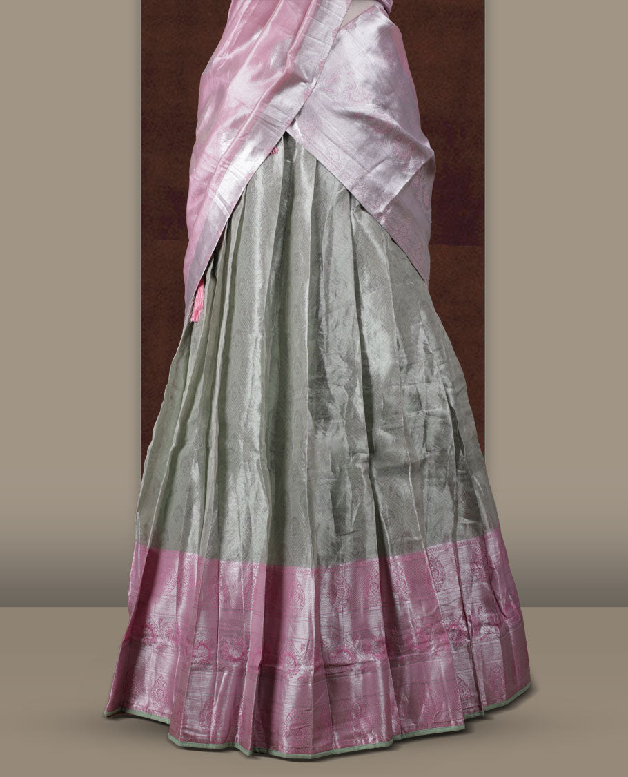 Light green and pink colour Dhavani set featuring a Light green colour skirt with contrast Pink colour border with rich silver zari pattern, paired with a contrasting Pink dupatta detailed with silver motifs