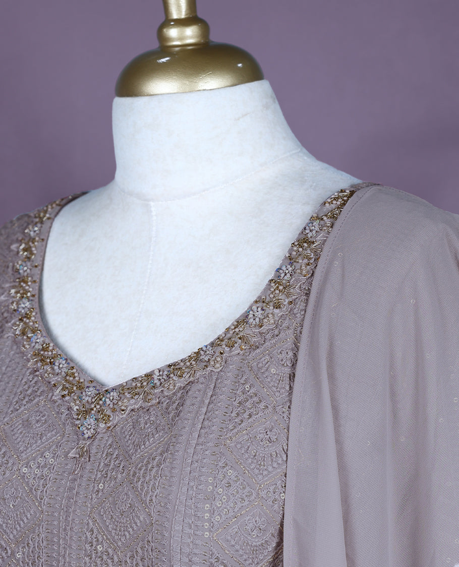 Taupe colour salwar set featuring a V neckline with subtle embellishments, three-quarter sleeves, intricate all-over embroidery, a matching chiffon dupatta, and a coordinated bottom