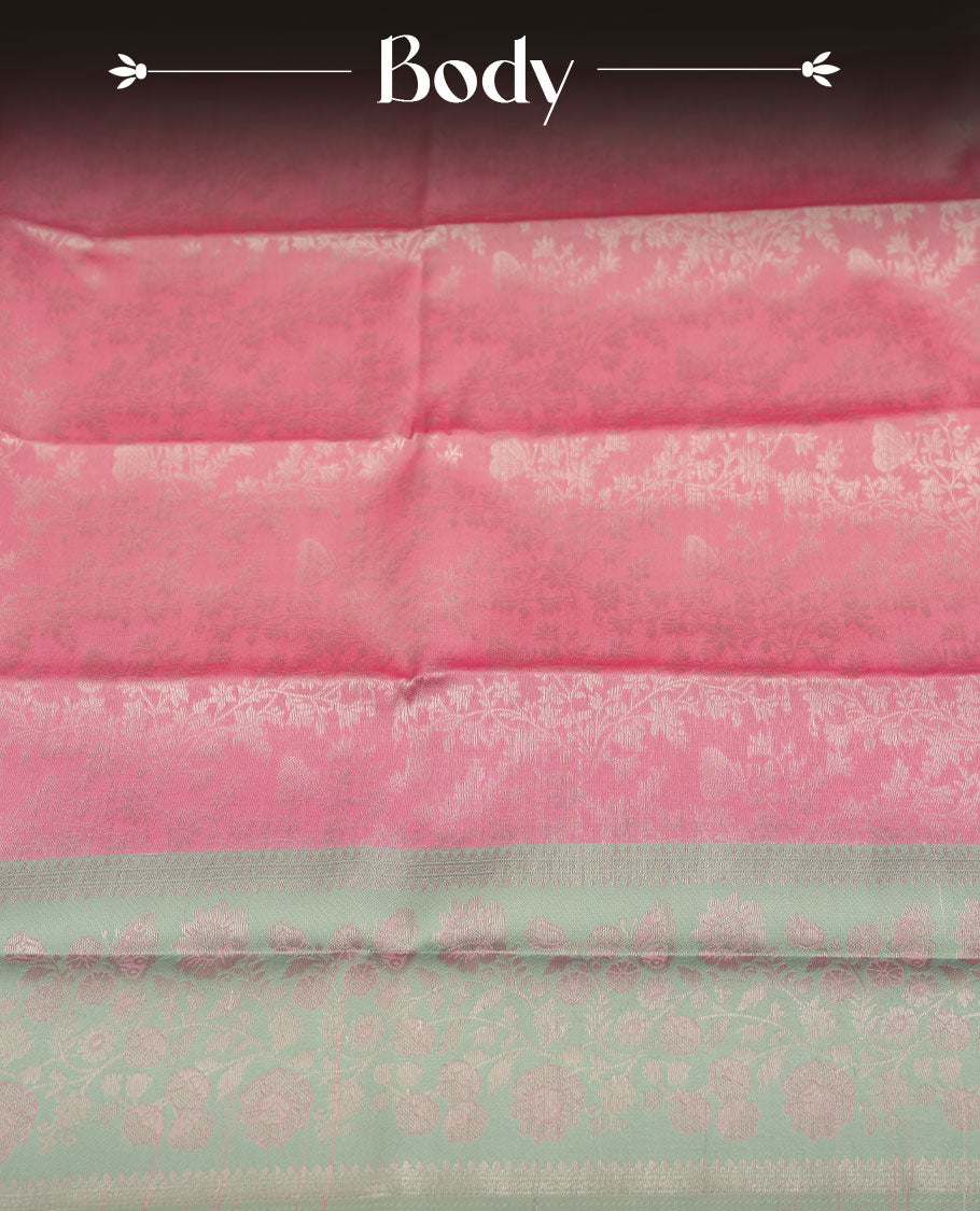 Pink colour semi silk saree adorned with subtle silver floral patterns on the body, complemented by contrasted a silver pallu intricately woven with rich floral patterns border and pallu, and paired with a matching blouse