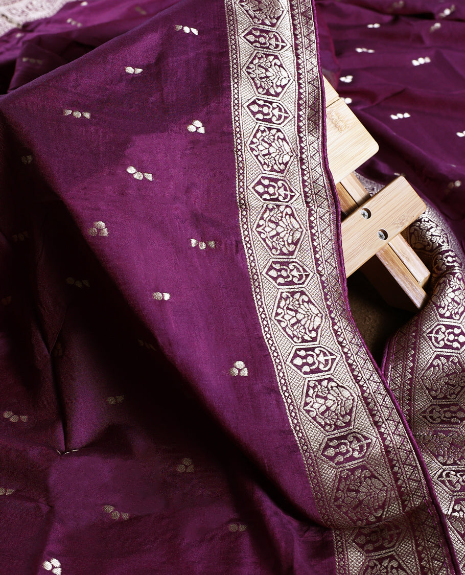 Grape colour churidhar material featuring golden zari woven motifs with an ornate traditional border, paired with a plain matching bottom and rich dupatta, perfect for weddings, festive occasions, and grand celebrations.