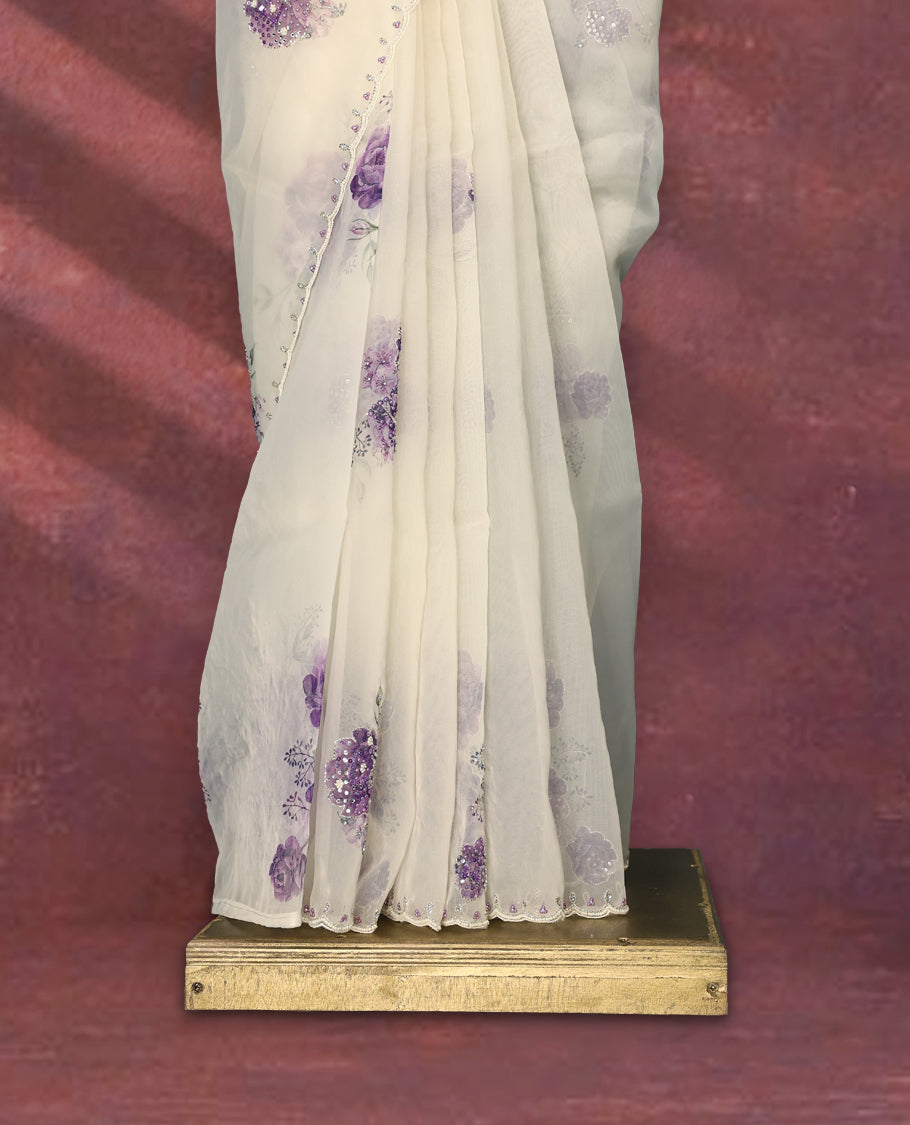 White colour pure organza saree featuring purple Colour floral prints with intricate bead and sequin work across the body, adorned with a matching embellished border, complemented by a worked pallu and paired with a heavily worked matching blouse.