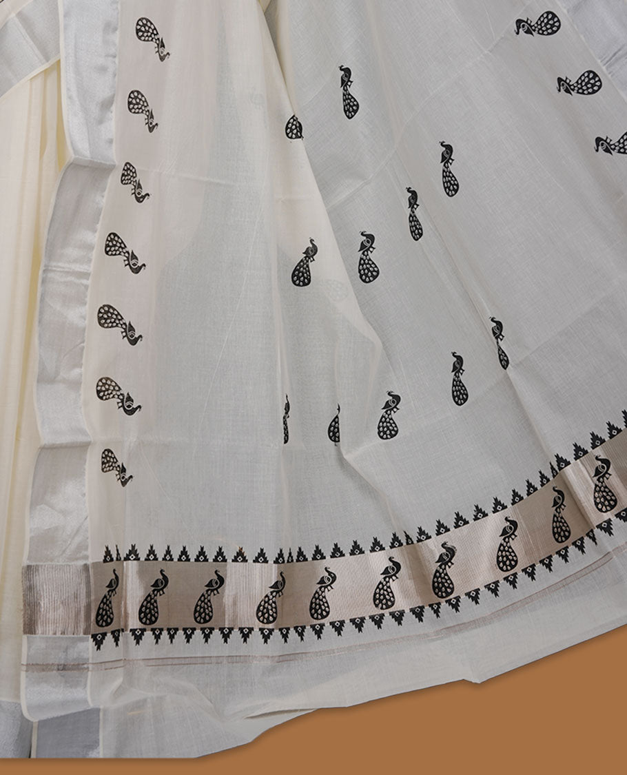 Off-white colour cotton Kerala saree featuring a subtle silver kasavu border, adorned with elegant black peacock motifs across the body and pallu, finished with a coordinated blouse for a refined, contemporary look.