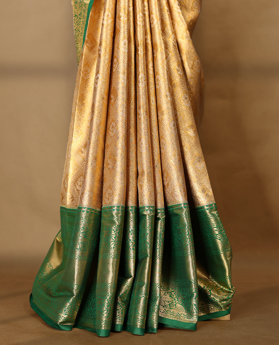 Gold colour tissue brocade saree with gold and silver zari flower and Diamond pattern on body, gold zari floral kodi work Green border, rich matching pallu with Antique zari motifs, paired with matching blouse.