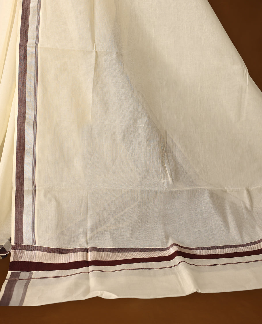 Classic off white colour cotton Kerala saree with elegant coffee brown and silver zari borders, exuding timeless charm. Paired with a matching blouse, perfect for traditional functions and cultural festivities.