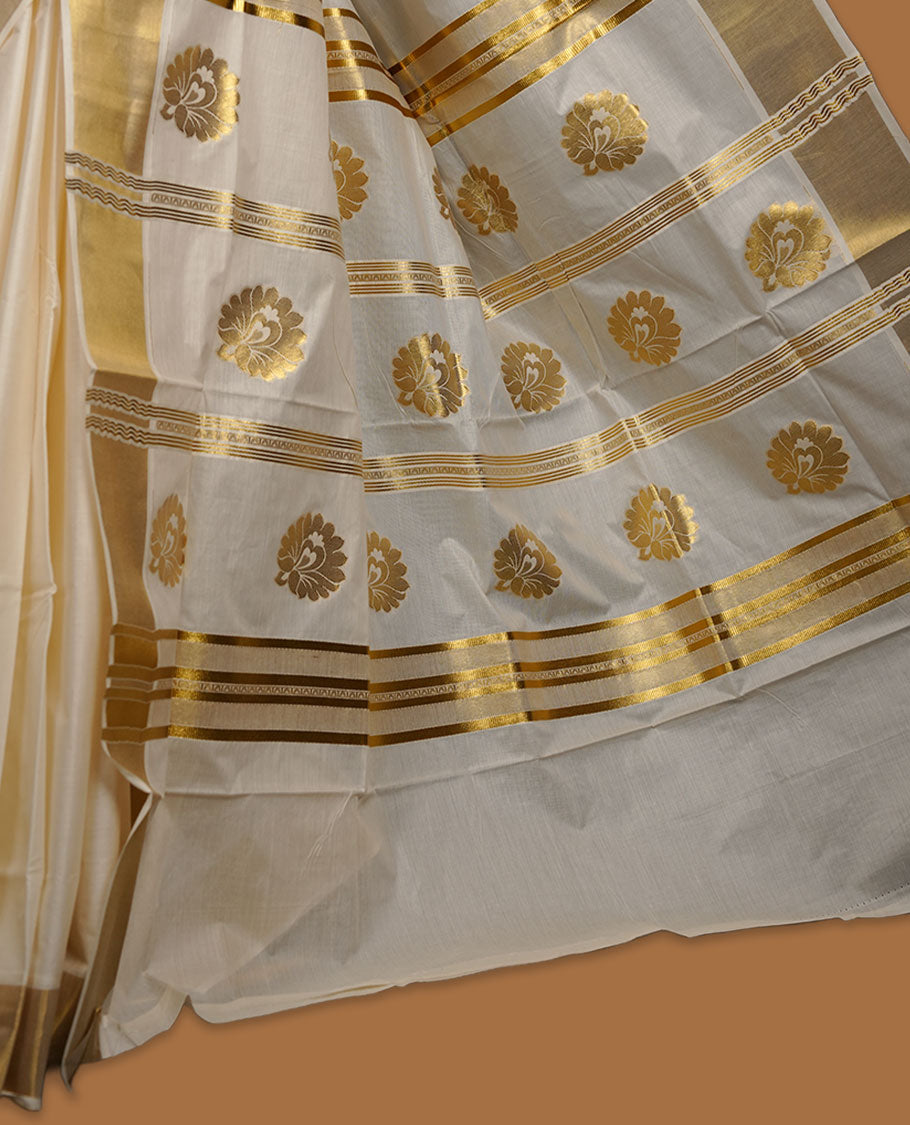 Off-White colour cotton Kerala saree adorned with subtle gold zari buttas, a broad kasavu border, and a richly woven traditional pallu, paired with a matching blouse.