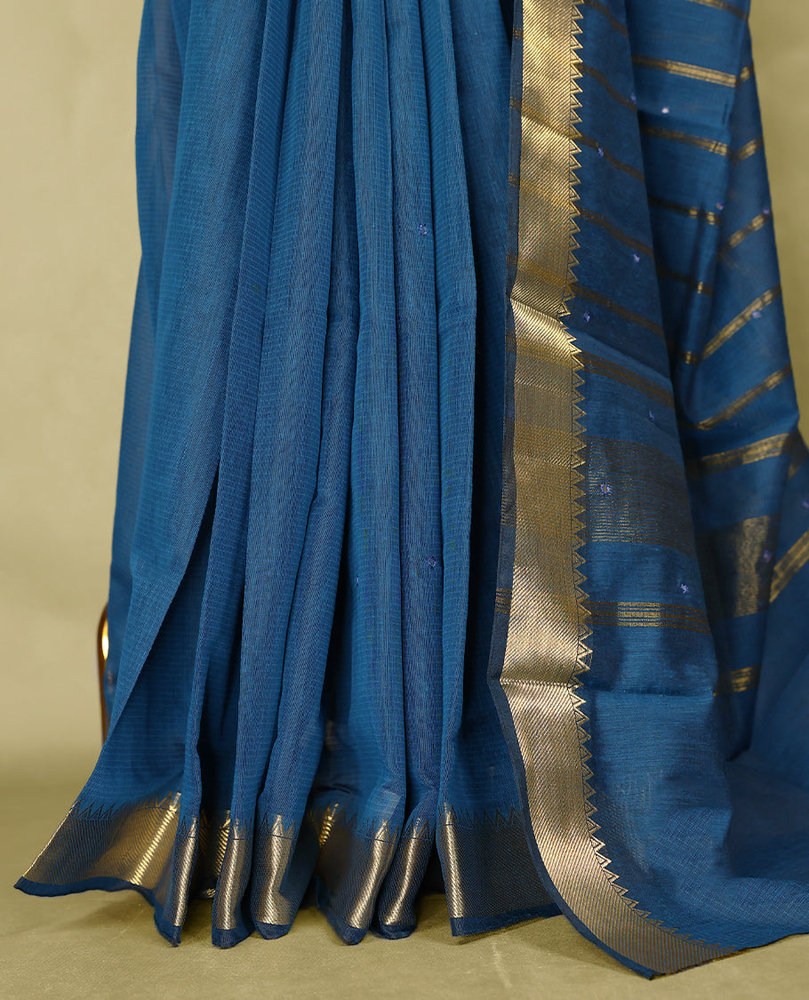 Blue colour Chanderi cotton saree featuring a subtly textured body with delicate buti work, complemented by a rich golden zari border with matching blouse
